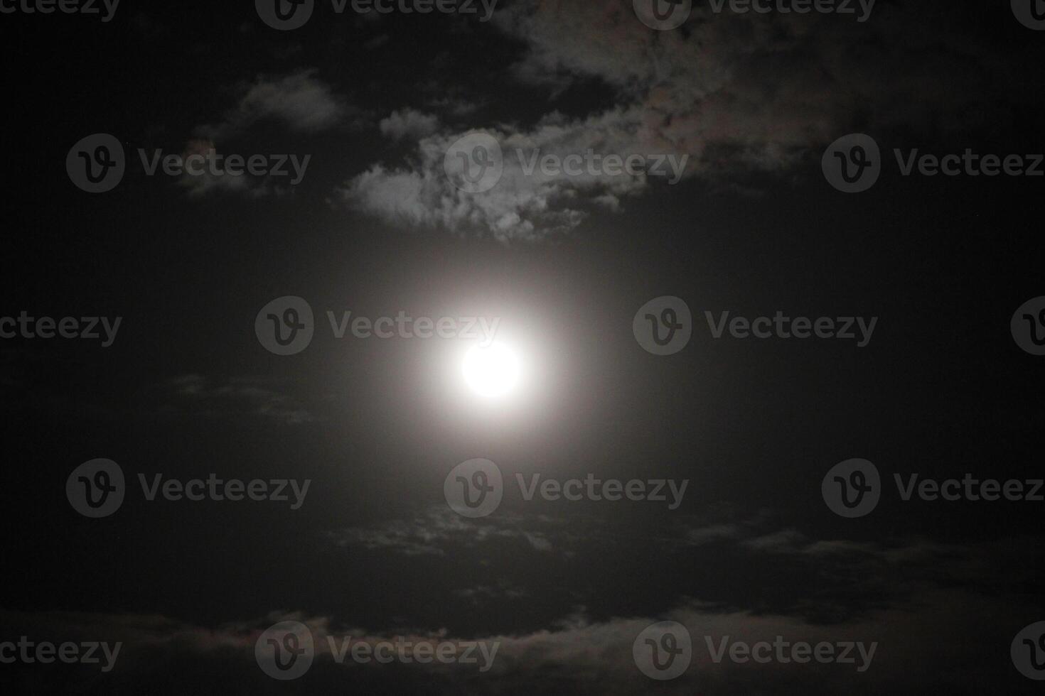 The moon is shining brightly in the dark sky photo