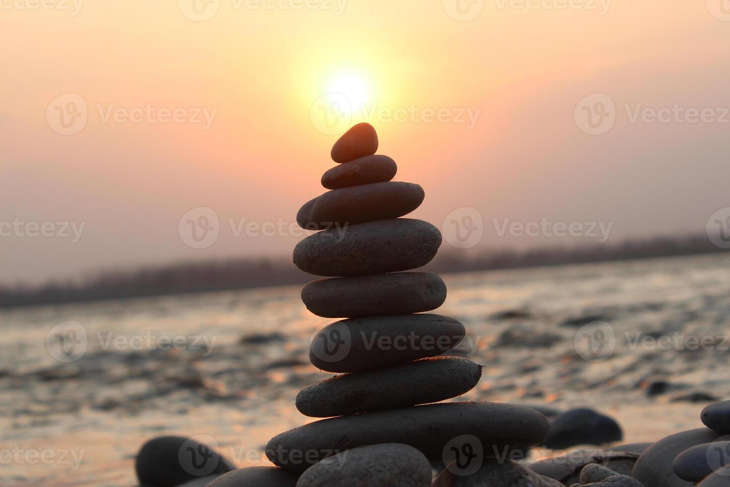 A stack of rocks on the beach at sunset photo