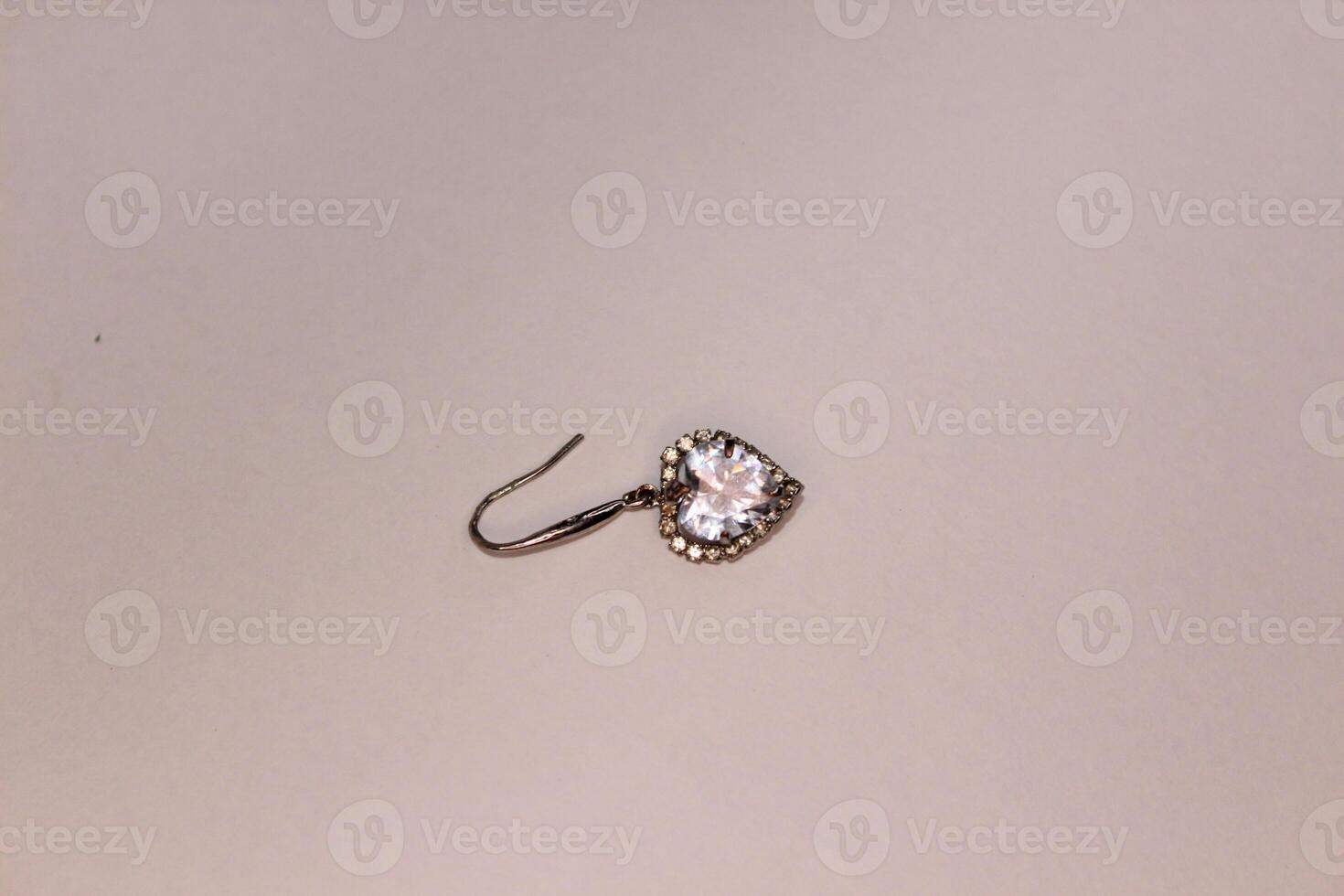 A small diamond earring on a white surface photo