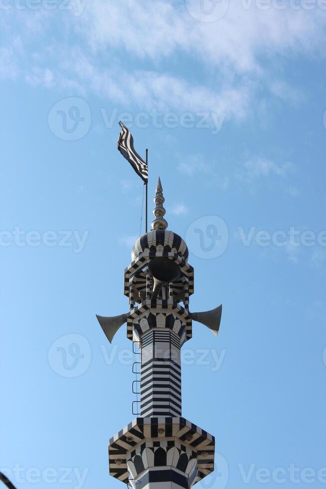 A large clock tower with a large black and white striped tower photo