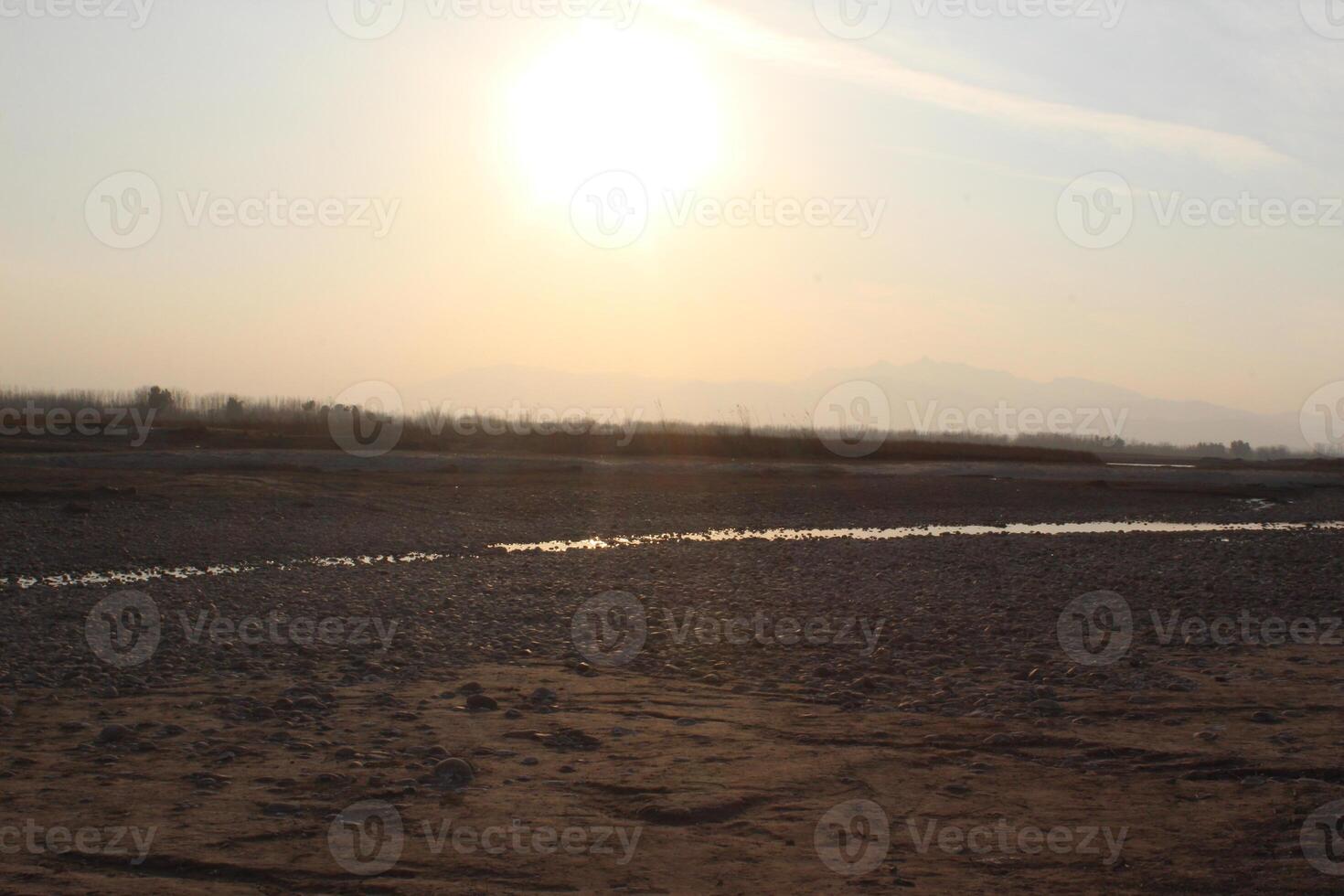 A person standing on a dirt field with a kite photo