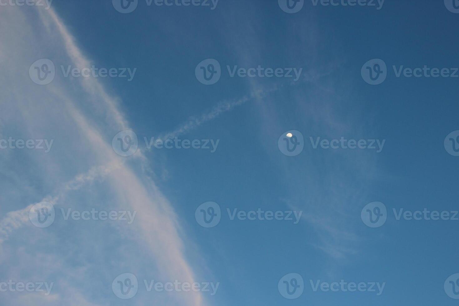 A plane flying in the sky with a contrail photo