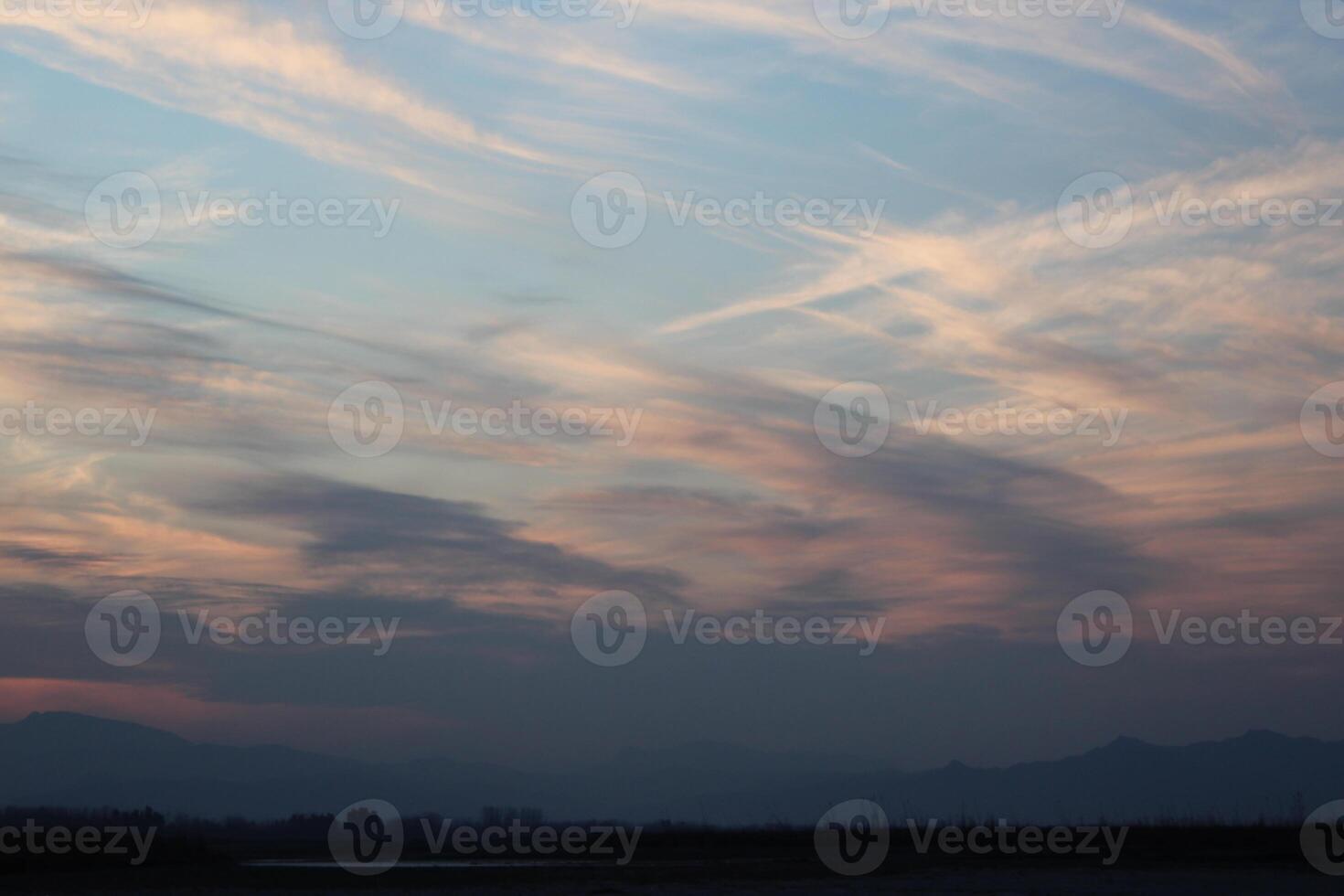 A plane flying over a field at sunset photo