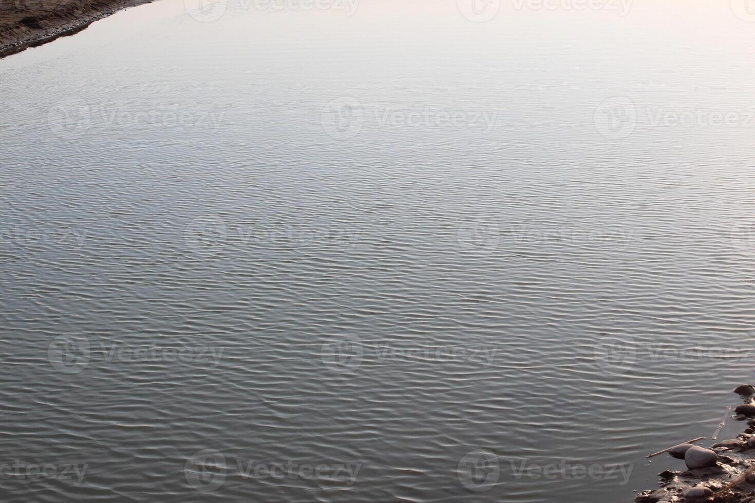 A man is standing on a rock next to a river photo