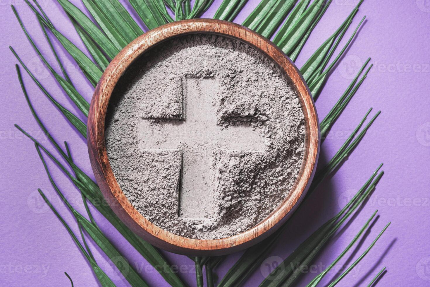 Bowl with cross imprint in gray ash on purple background. Ash Wednesday photo