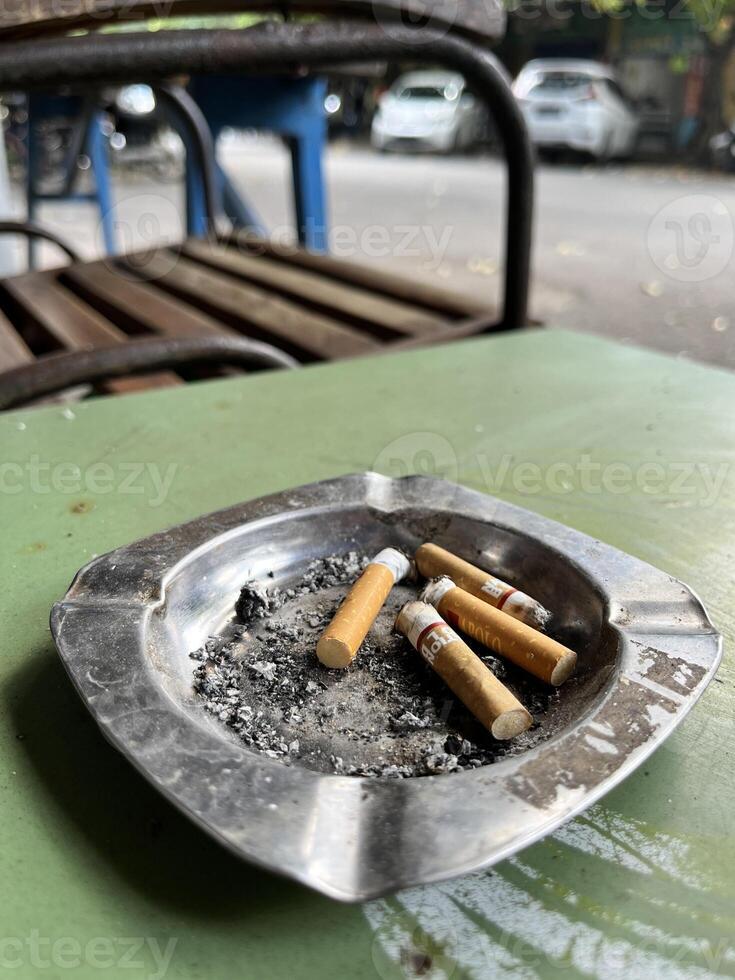 a cigarette is sitting on a metal tray on a table photo