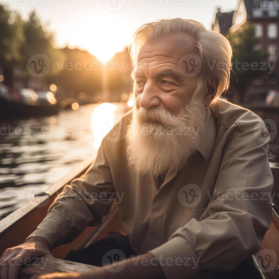 An older man with a beard and white hair is sitting in a boat on a river photo