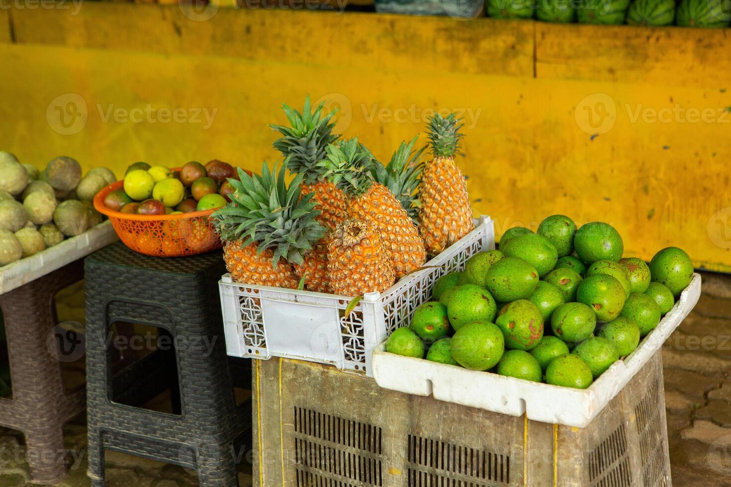 A basket filled with an assortment of tropical fruits like guava, soursop, and rambutan at a vibrant Sri Lankan market. photo