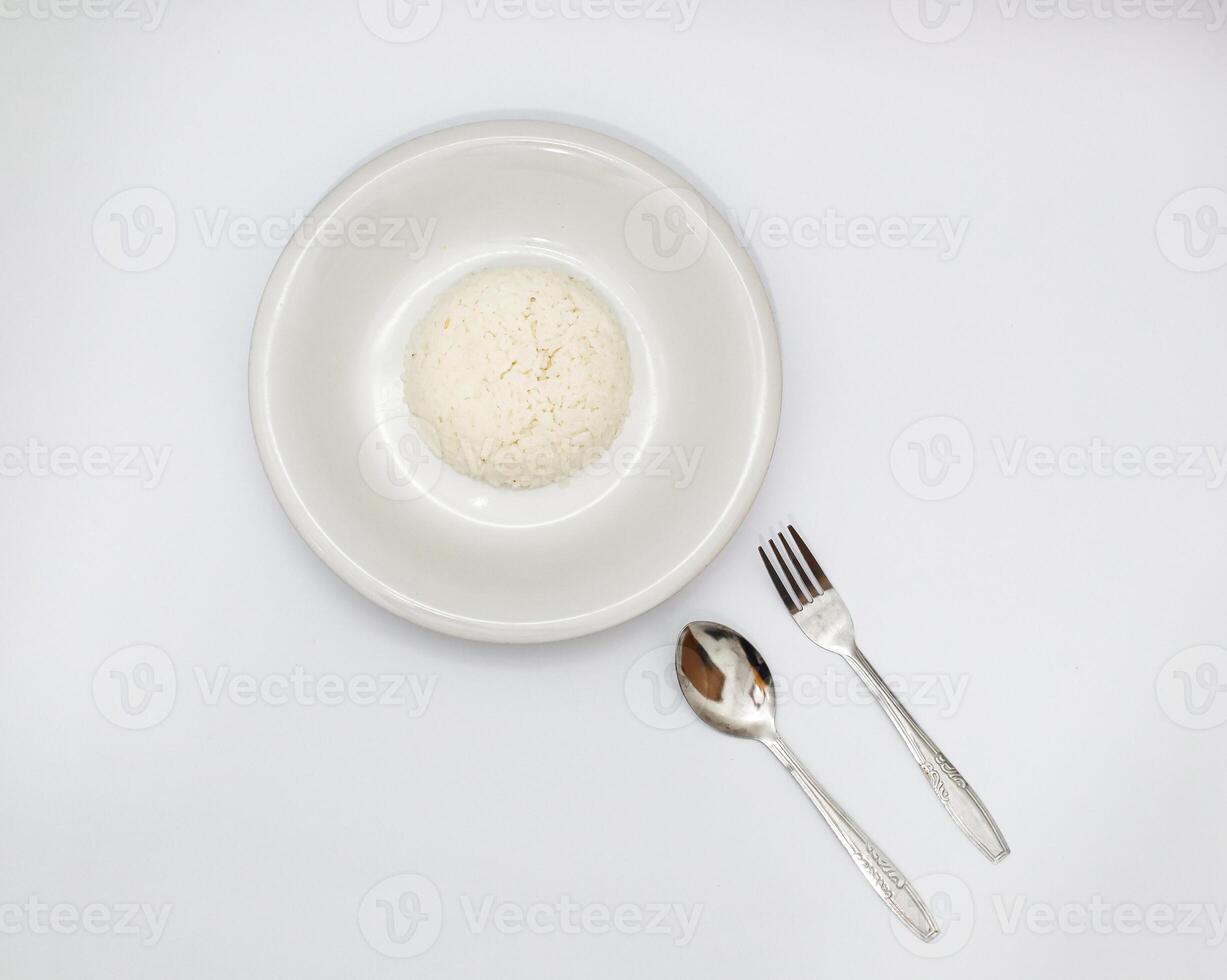 Overhead View of Steamed Rice on White Plate with Spoon and Fork photo