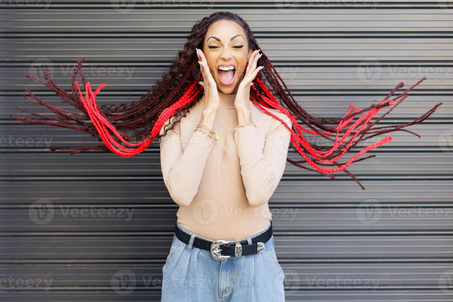 An Excited Woman with Striking Red Braids Expressing Pure Joy Against a Stylish Background photo