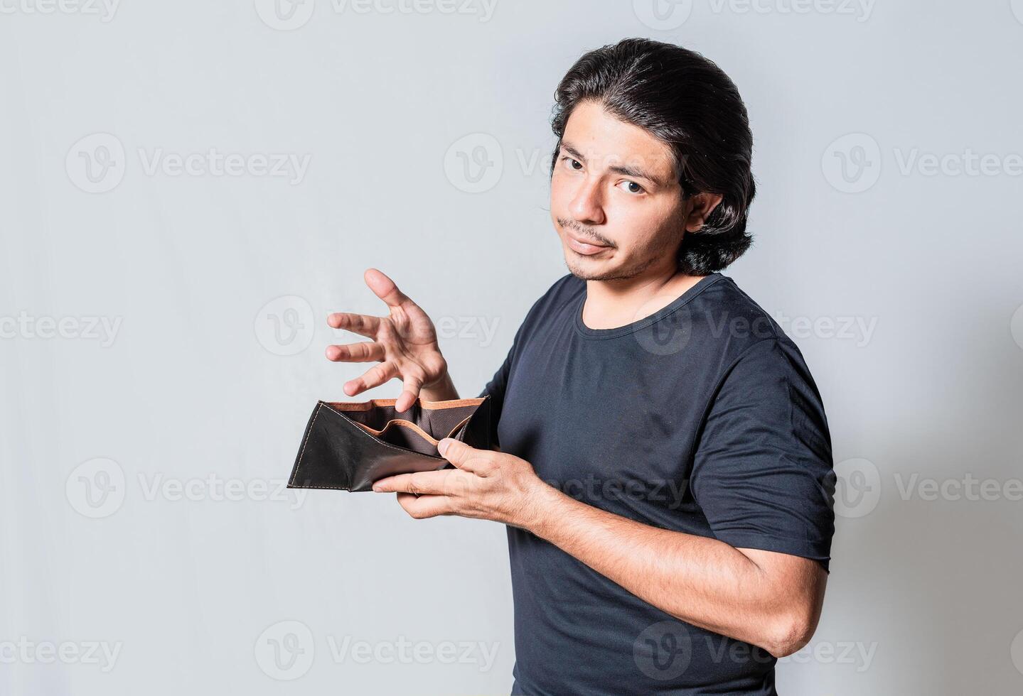 Young man with financial crisis holding wallet isolated. Sad man holding empty wallet. Unhappy man with financial crisis isolated photo