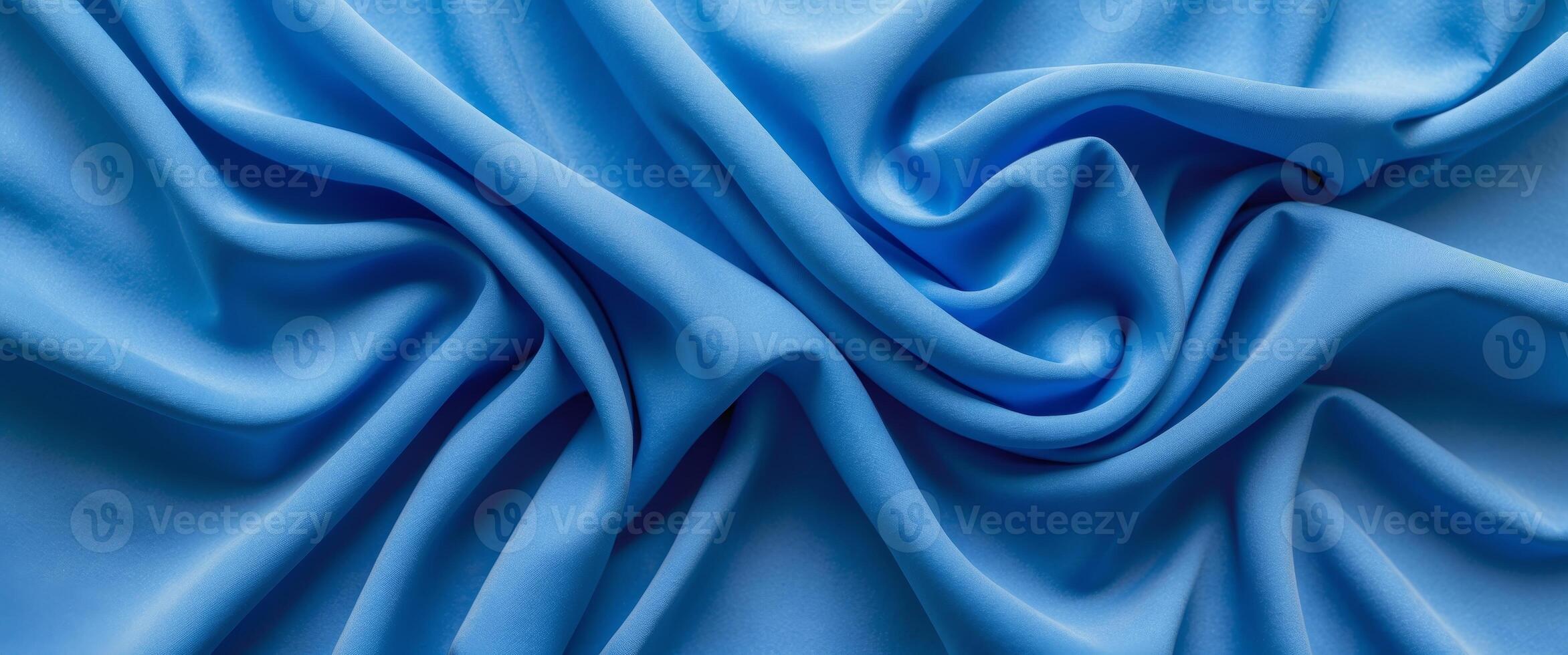 Vibrant blue fabric texture with elegant wrinkles and folds creating a dynamic visual flow suitable for design and textile backgrounds photo