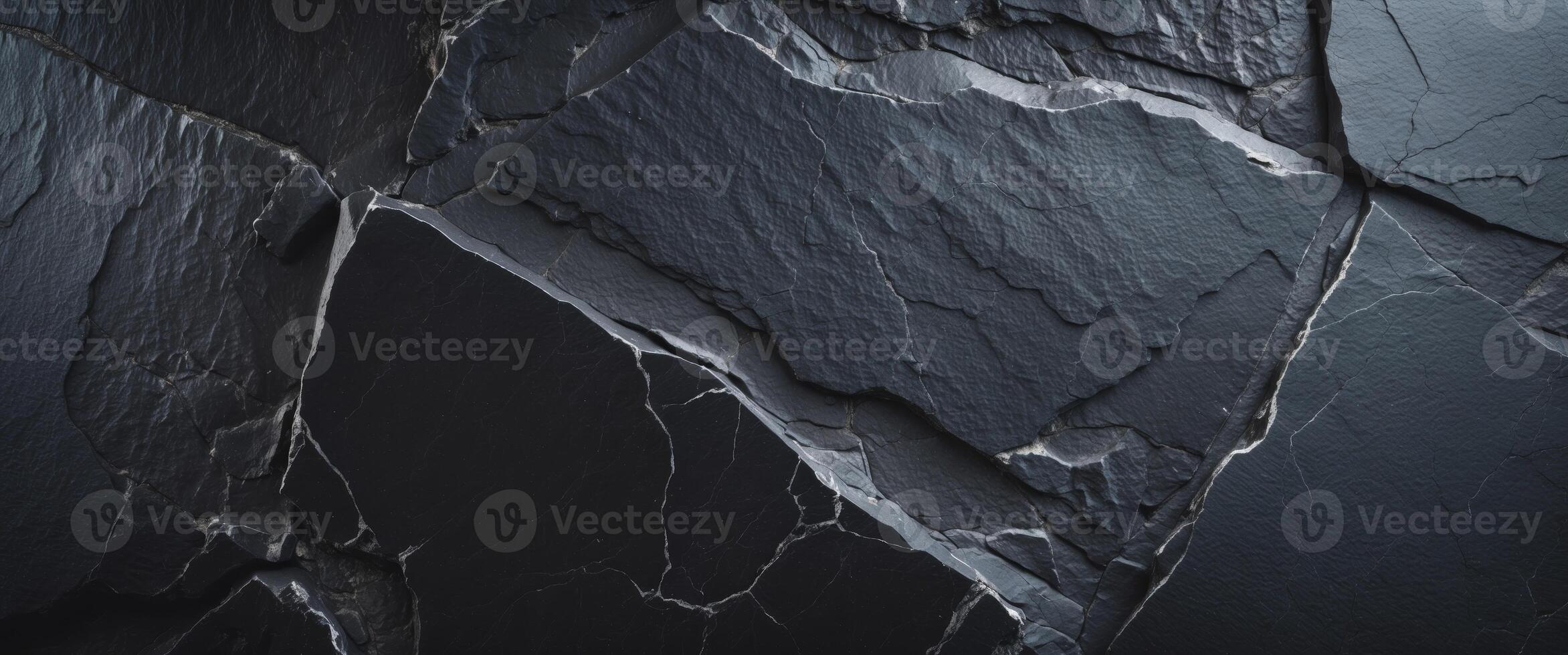 Black slate rock background texture with a rough and uneven surface creating a dark and moody backdrop photo