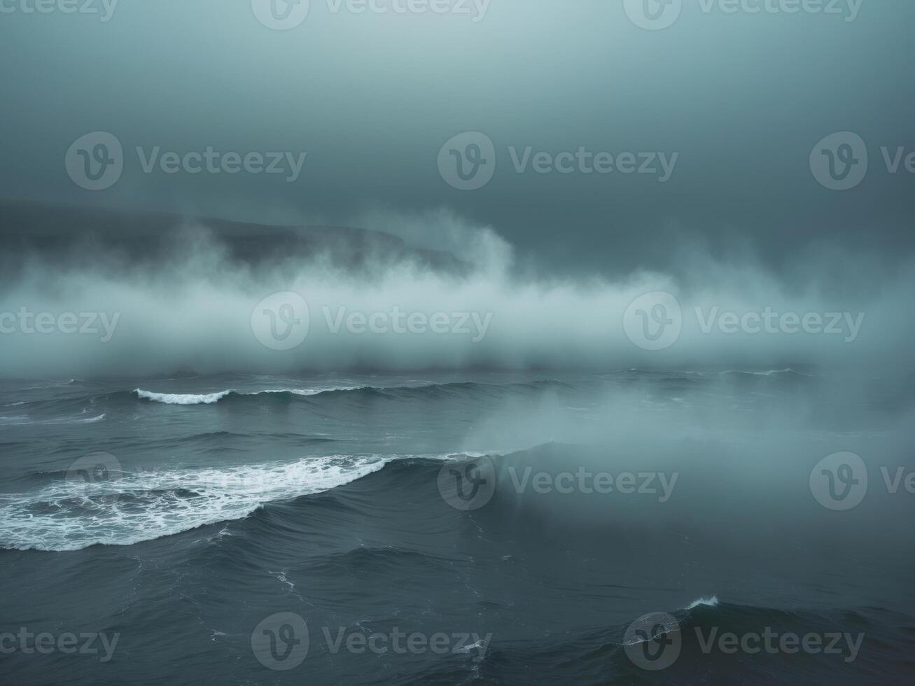 Fog rolling over a deep blue ocean water surface creating a mystical and moody atmosphere. photo