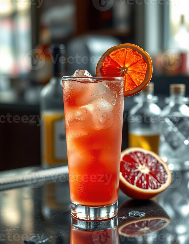 Refreshing cocktail with citrus garnish served in a bar setting during the evening photo
