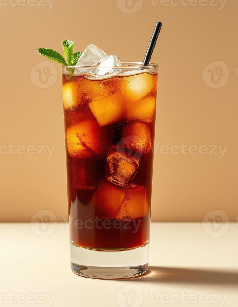 Refreshing iced tea with ice cubes and mint leaf served in a tall glass on a smooth surface photo