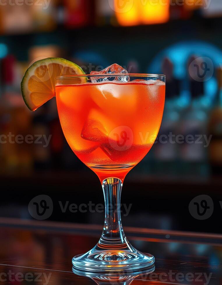 Colorful cocktail served in elegant glass with lemon slice at bar setting during evening hours photo