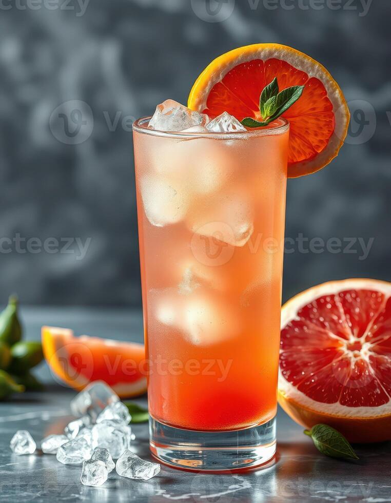 Refreshing citrus drink served in a tall glass with ice and garnished with orange slice and mint leaves photo