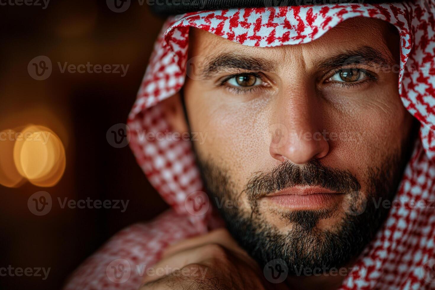 man stands in front of mirror adjusting his ghutra and black agal. He is focused and readying himself for Friday prayer reflecting his cultural traditions photo