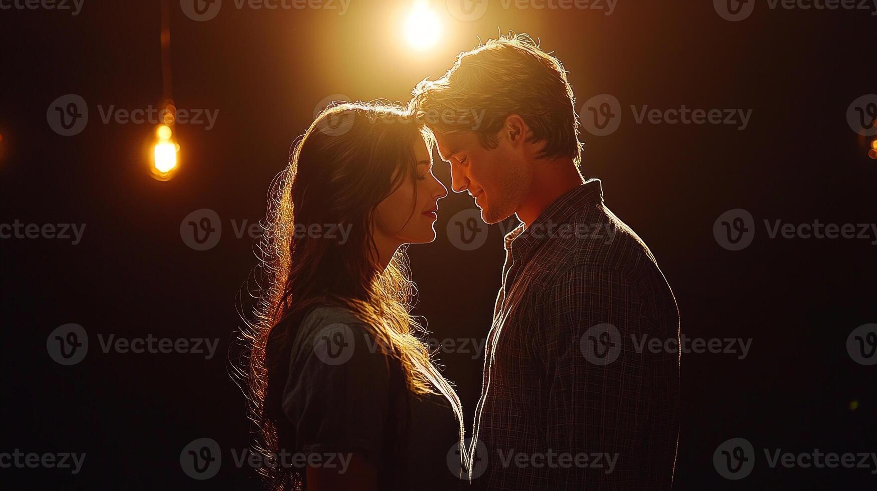 Two actors stand closely together in dimly lit backstage area whispering lines while preparing step onto stage. Their intense focus contrasts distant sounds of laughter photo