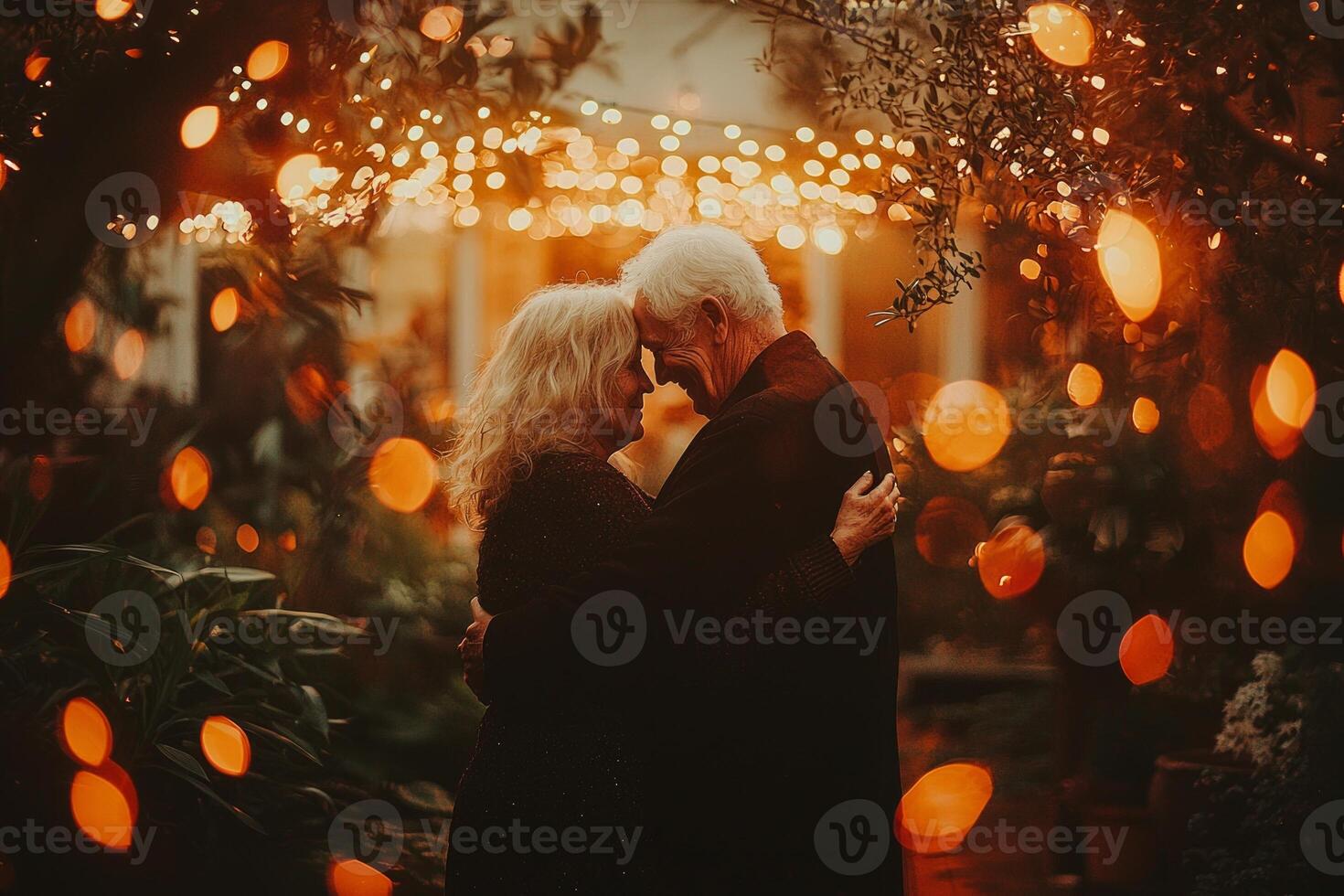 elderly Caucasian couple shares tender moment while dancing warm glow of string lights in their backyard. soft motion blur adds whimsical touch their joyful evening photo