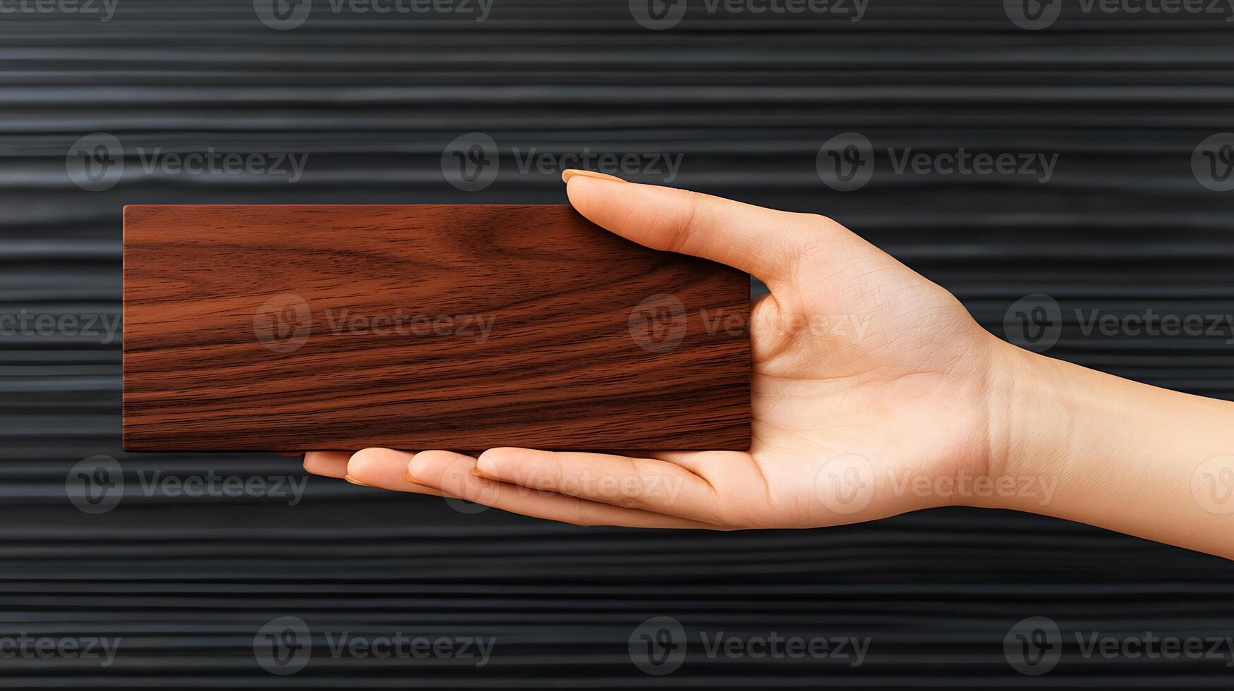 A hand holding a wooden card on a black background photo