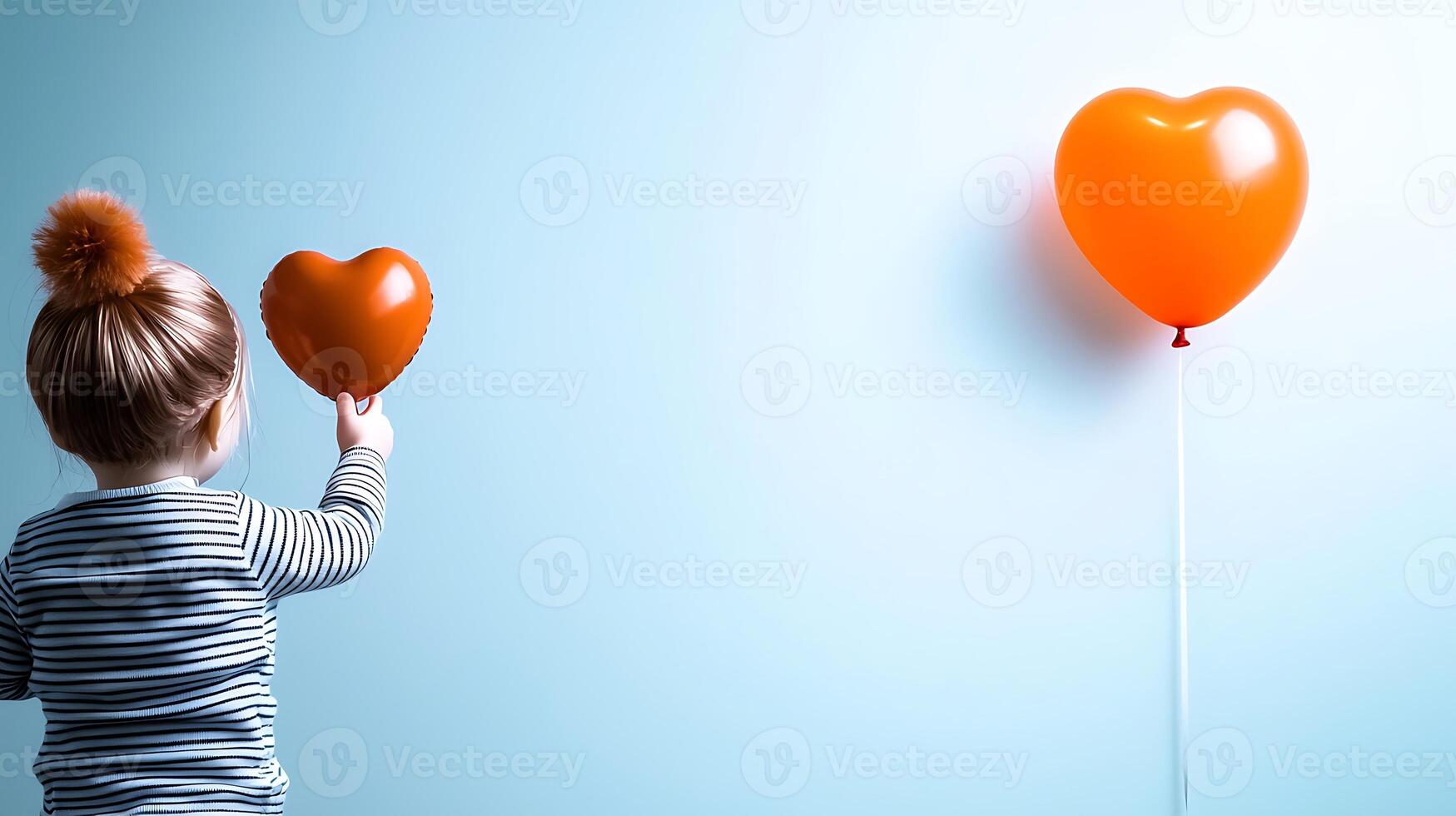 A little girl holding an orange heart shaped balloon photo