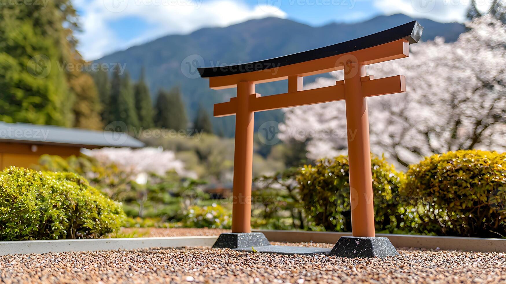 A tori gate in a garden with a mountain in the background photo