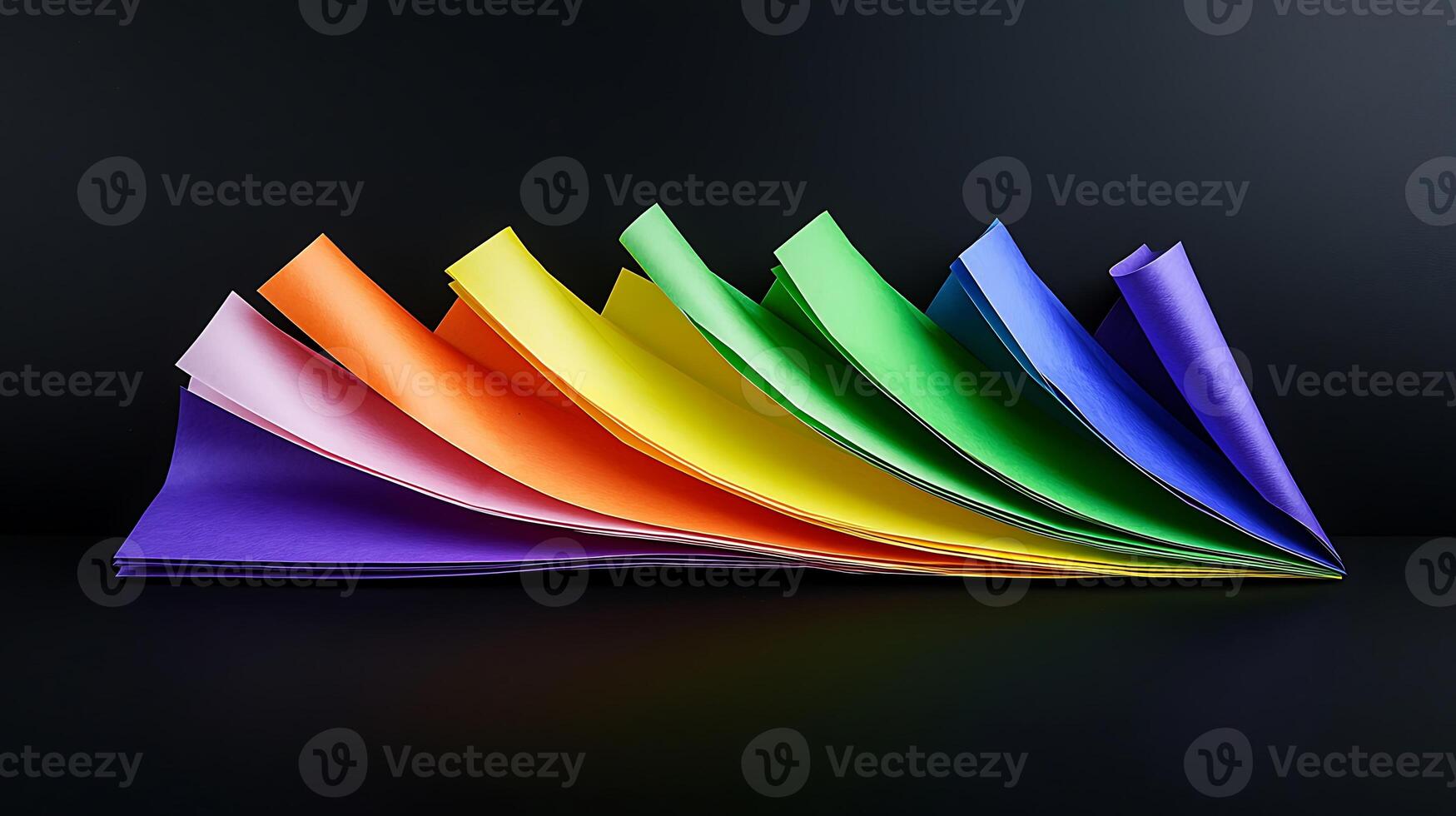 A rainbow colored folded paper on a black background photo