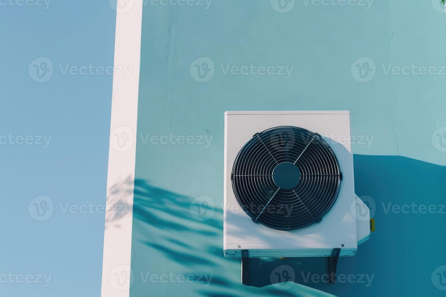 Modern air conditioning unit against minimalistic light blue background wall.. photo