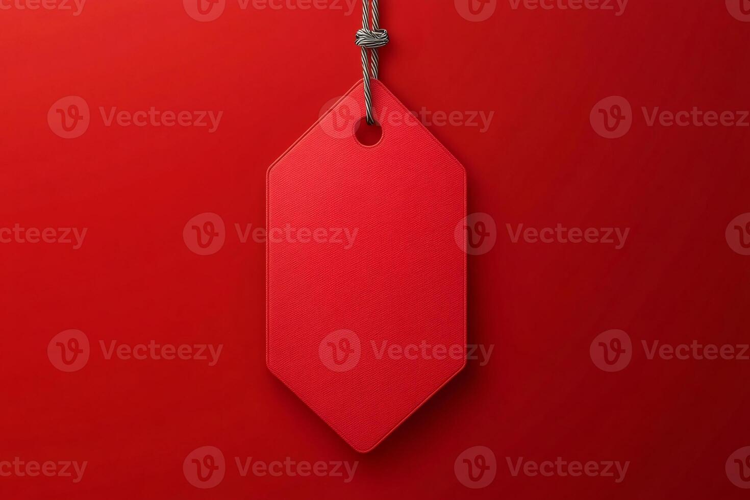 Red label hanging from string on red background photo