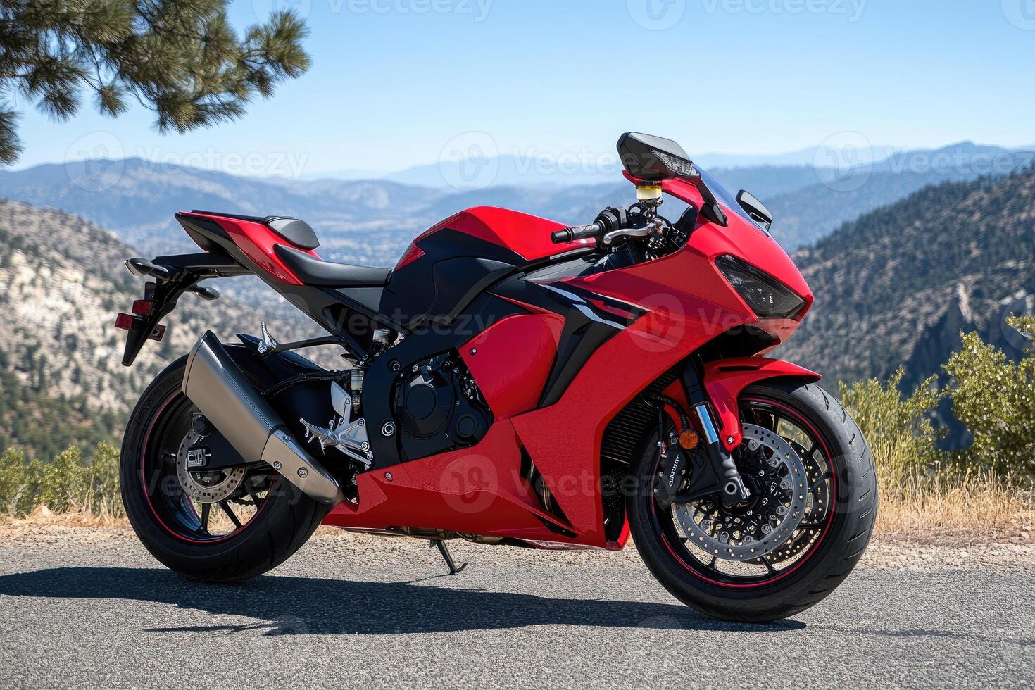 Red motorcycle parked on a mountain road overlooking a valley photo