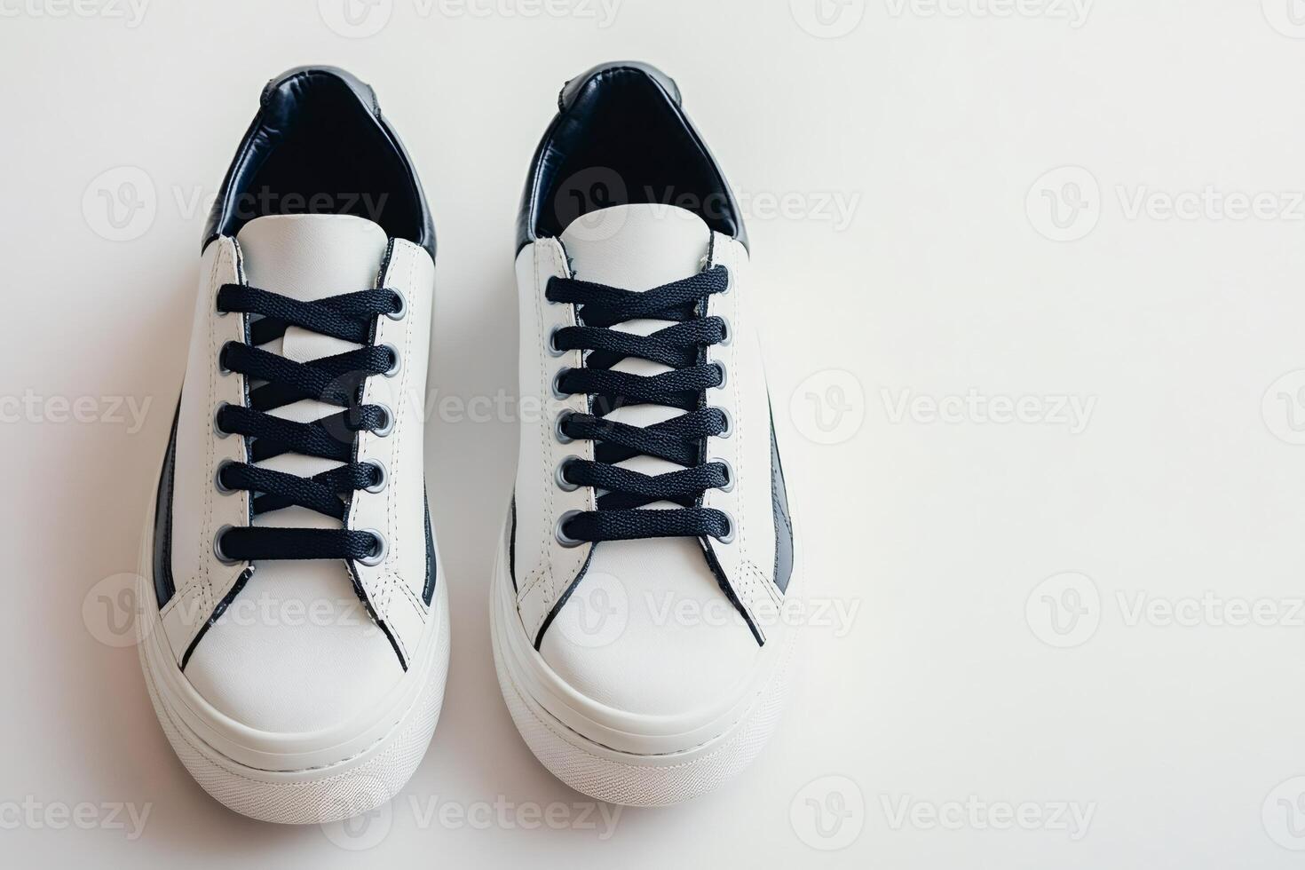 Pair of white sneakers with black laces on white background photo