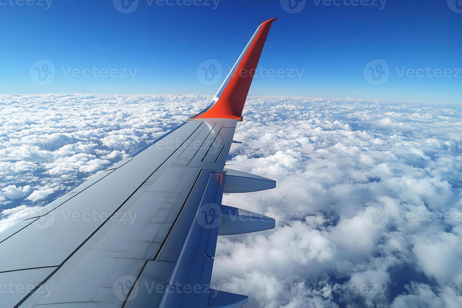 Airplane wing soaring above a breathtaking expanse of clouds under a clear blue sky photo