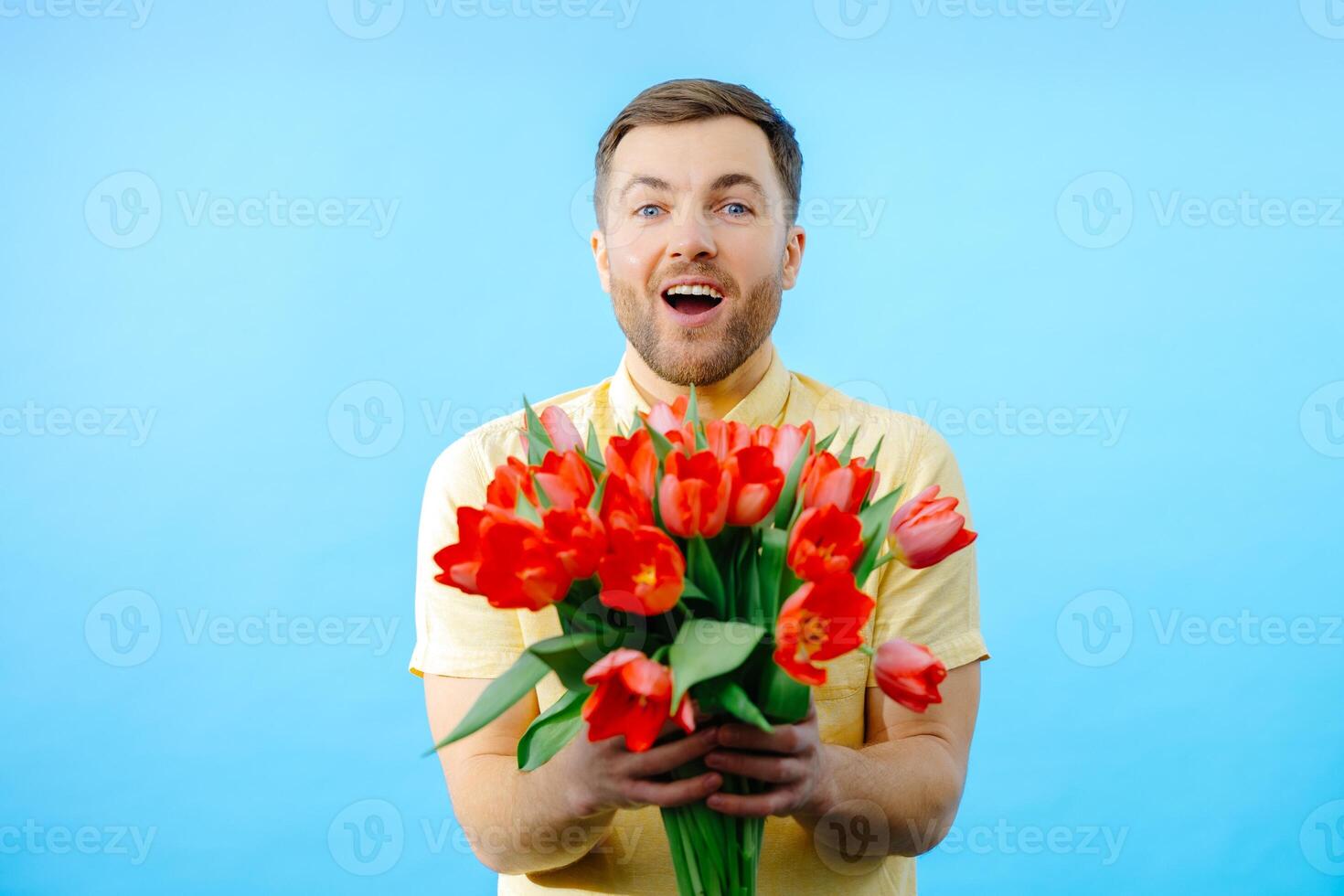 Man holding bunch of red flowers in hands photo