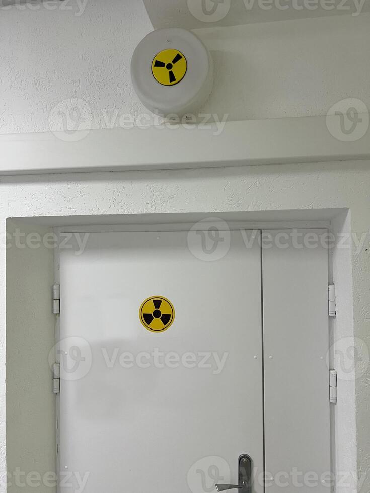 Radiation hazard sign on door indicating restricted area in laboratory or facility photo