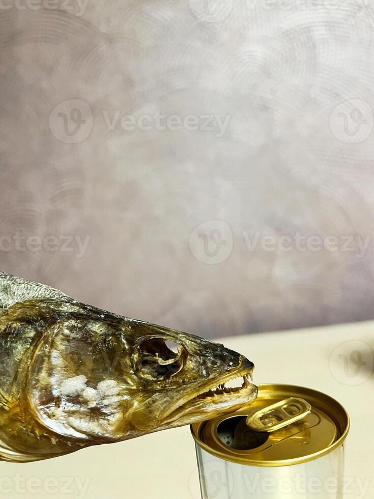 Dried fish head interacting with an opened canned beverage photo