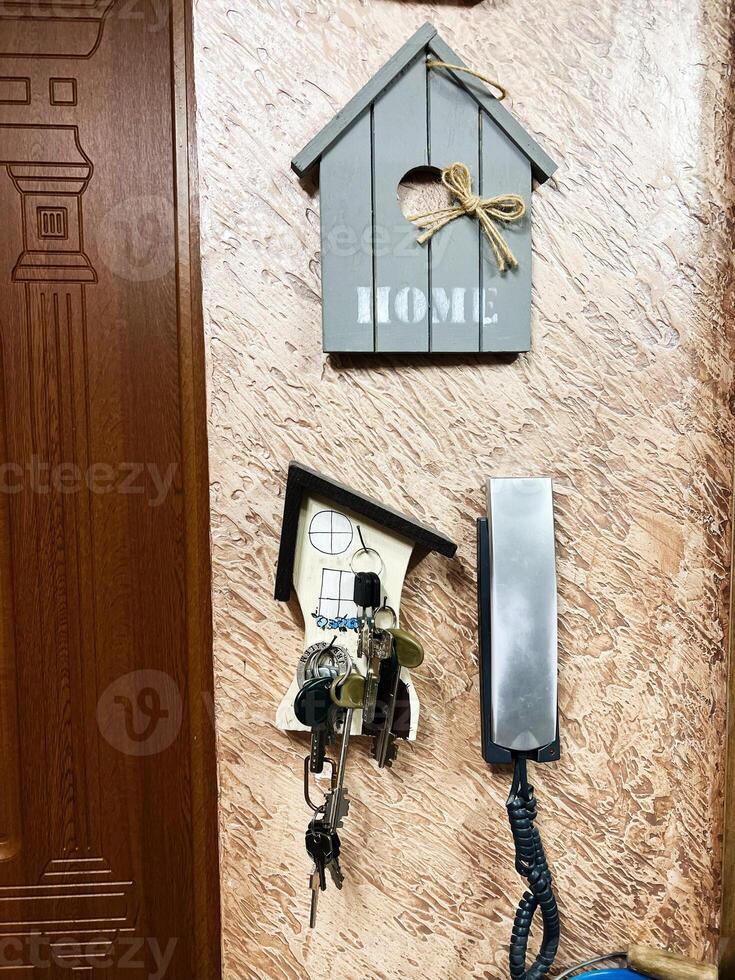 Wooden key holder and telephone on a decorative textured wall photo