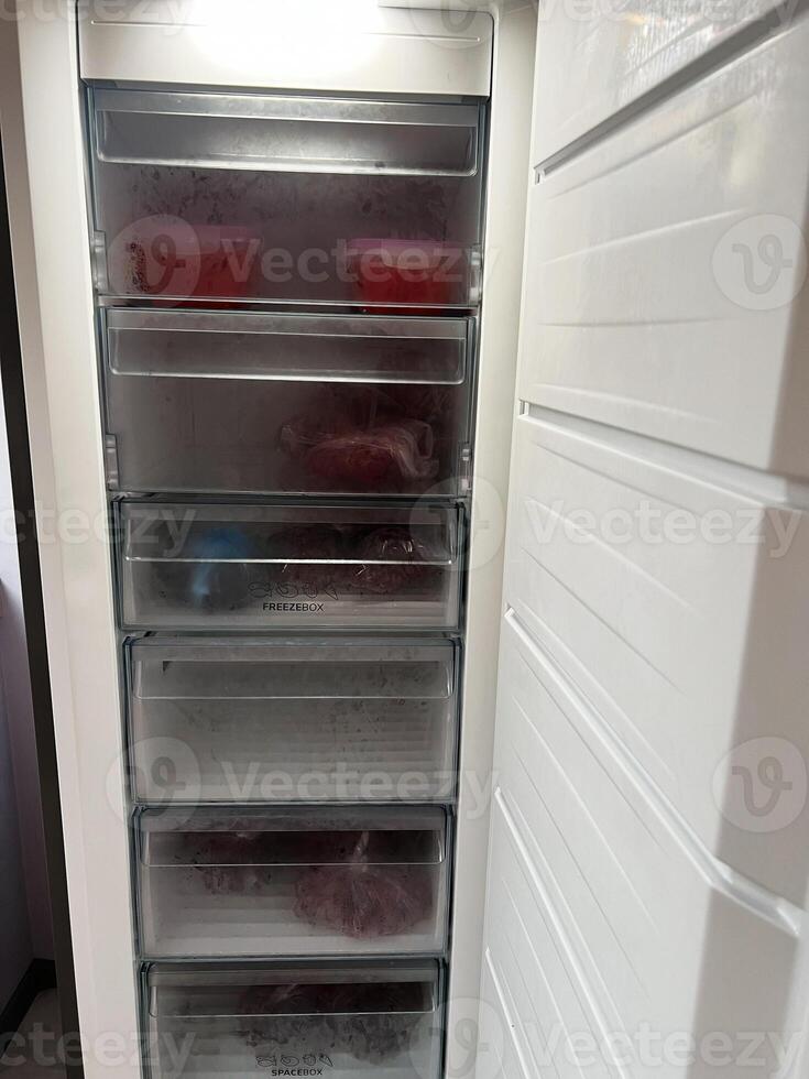 Organized freezer with transparent drawers and stored frozen food items photo