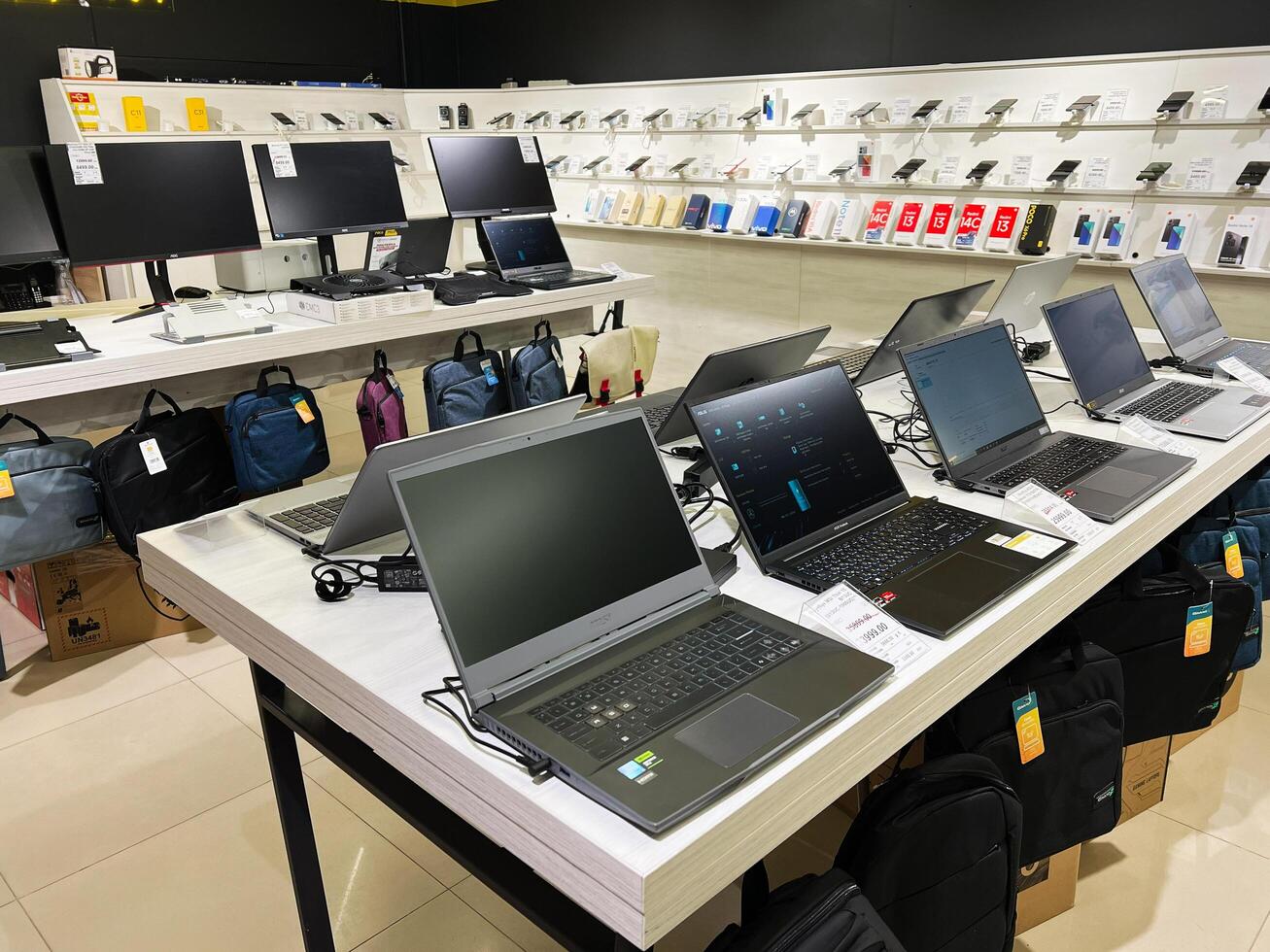 Kyiv, Ukraine - February 04, 2025 Modern electronics store showcasing laptops, monitors, and accessories on stylish displays photo