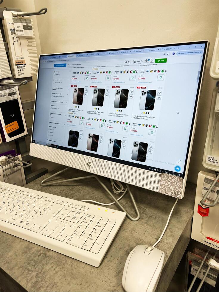 Kyiv, Ukraine - February 04, 2025 Monitor displaying online store interface with Apple Iphone smartphones on a desk in a shop photo