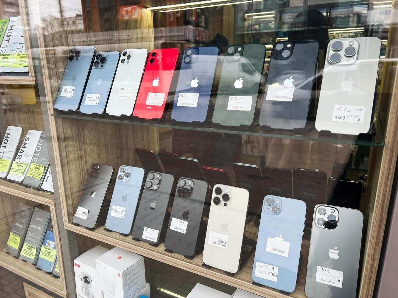 Kyiv, Ukraine - February 04, 2025 Showcase of used modern Iphone smartphones on display in a retail store glass cabinet photo