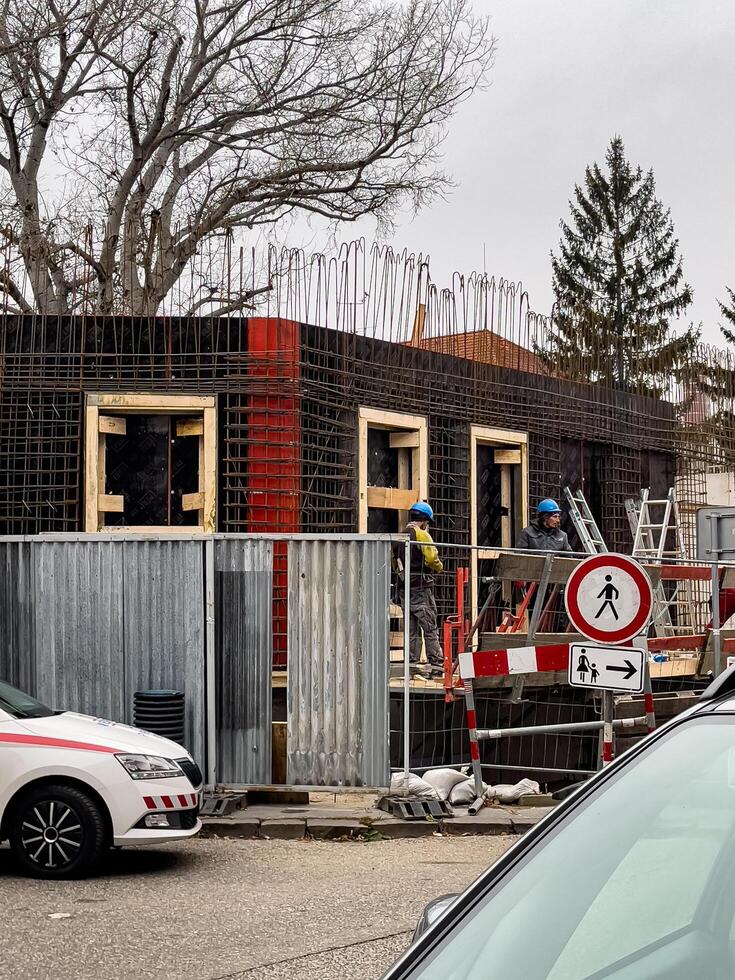 Nitra, Slovakia - 12.06.2024 Construction of a building in the city. Builders processing window openings. photo