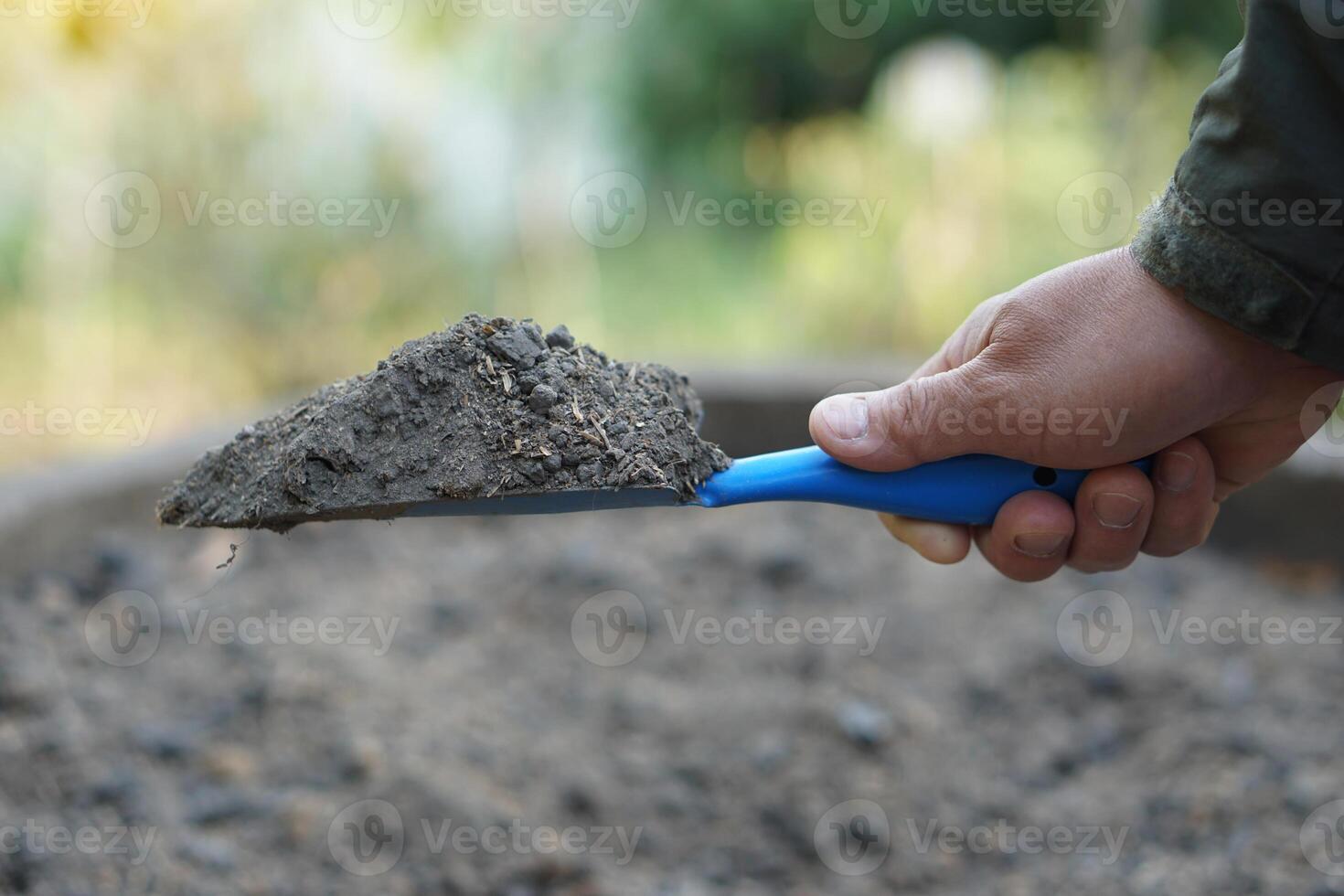 Close up hand held trowel of sample soil in garden. Concept, soil quality inspection, research and development for agriculture product. Find the best from different soil type and source photo