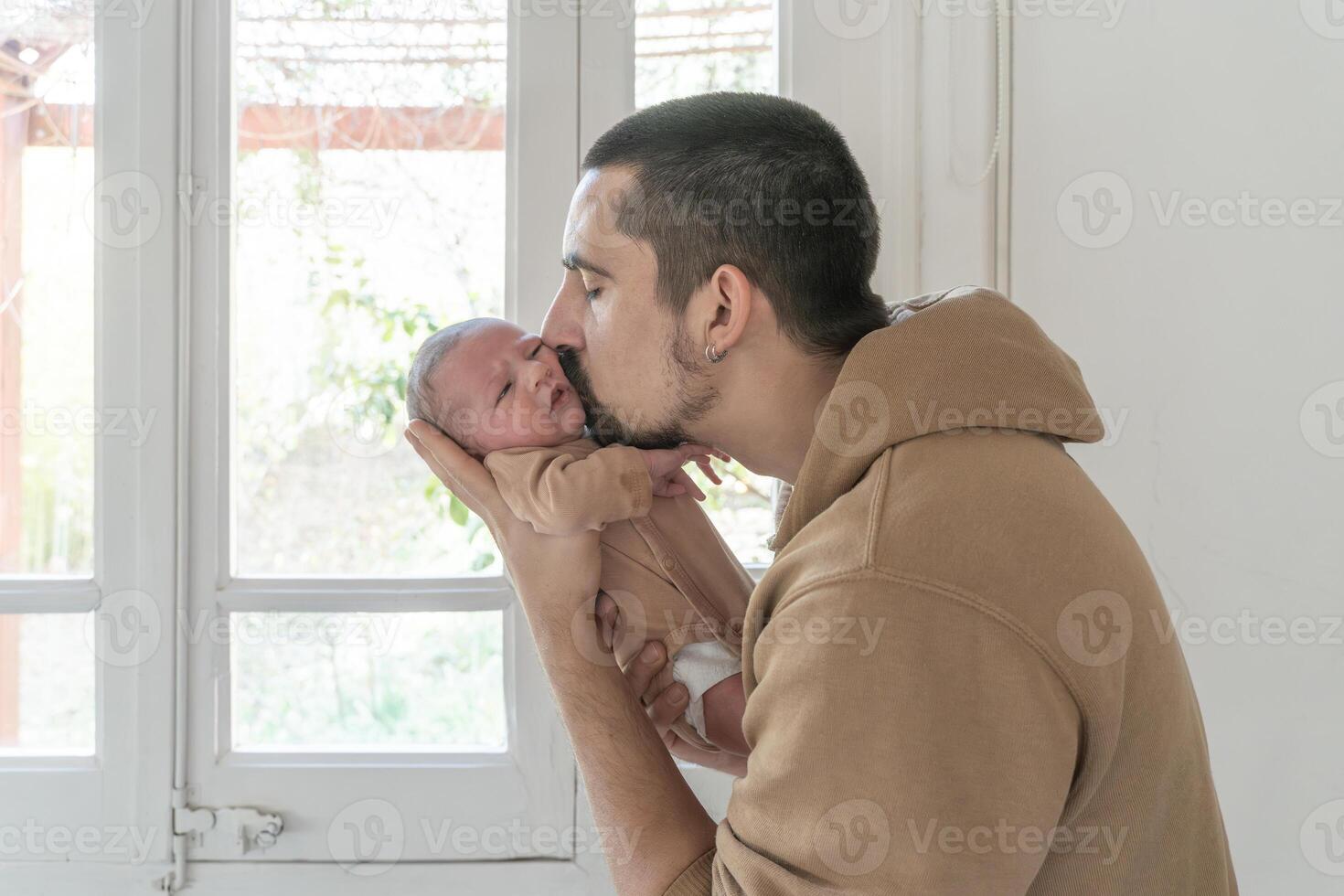 Father kissing his newborn daughter. photo