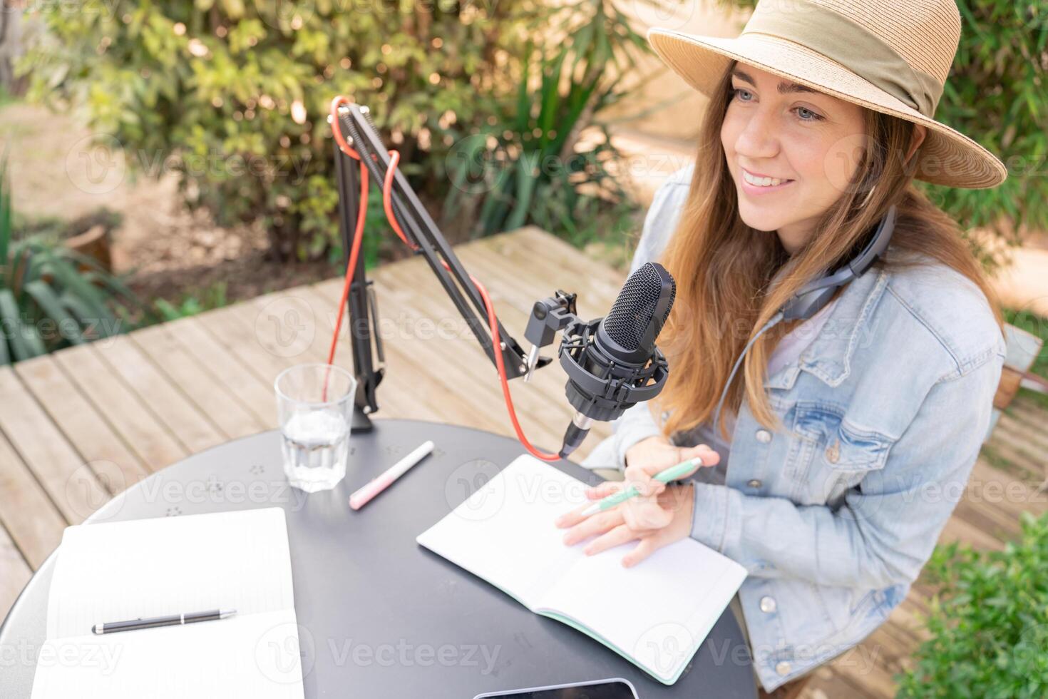 Attractive woman recording radio podcast - Young girl talking during live stream session outdoor photo