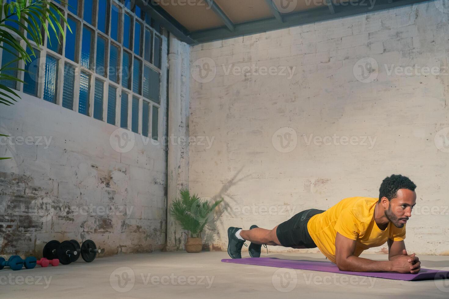 Muscular black man performing plank. Fitness workout concept. photo