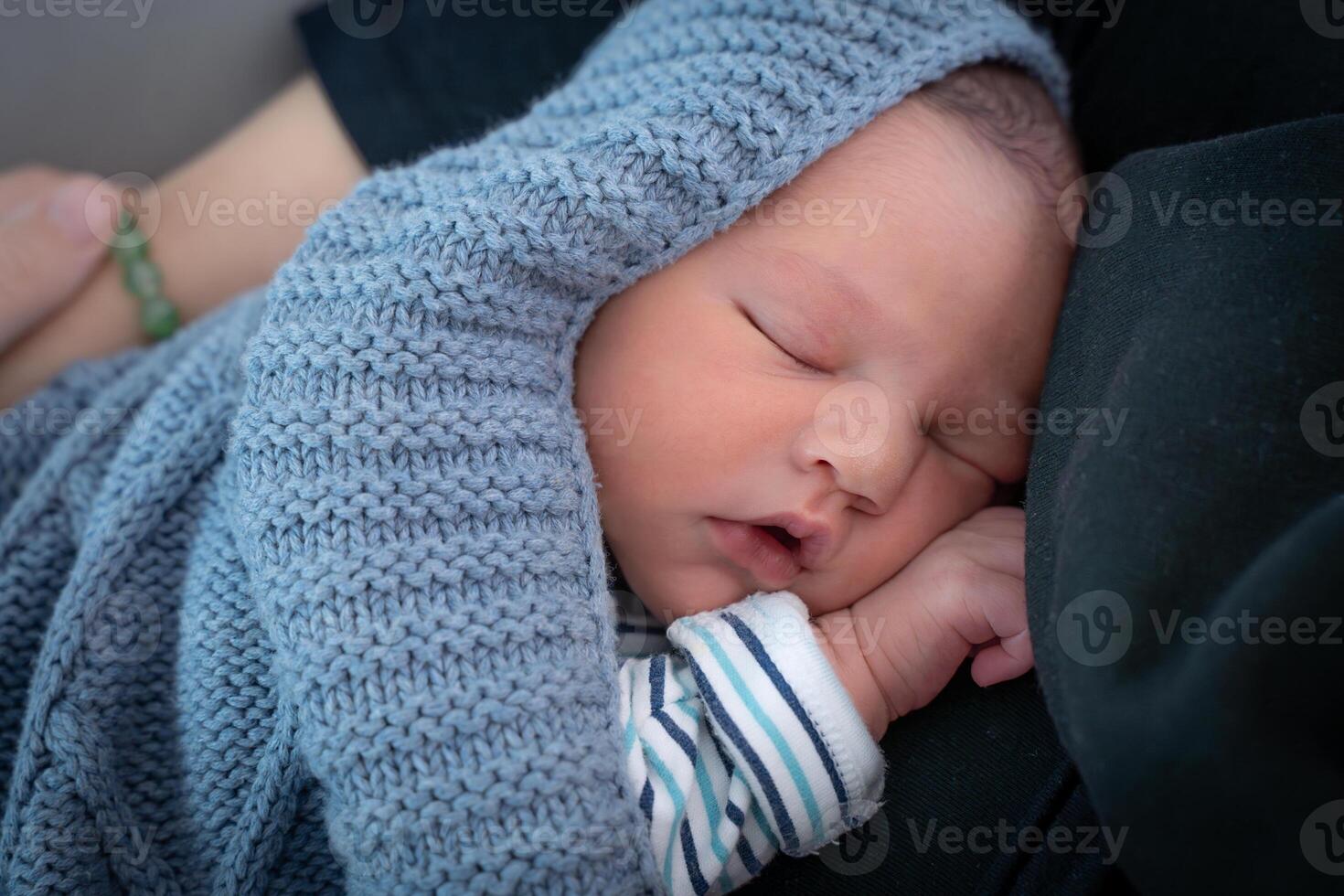Sleeping newborn baby in a wrap on blanket. Beautiful portrait of little child. photo