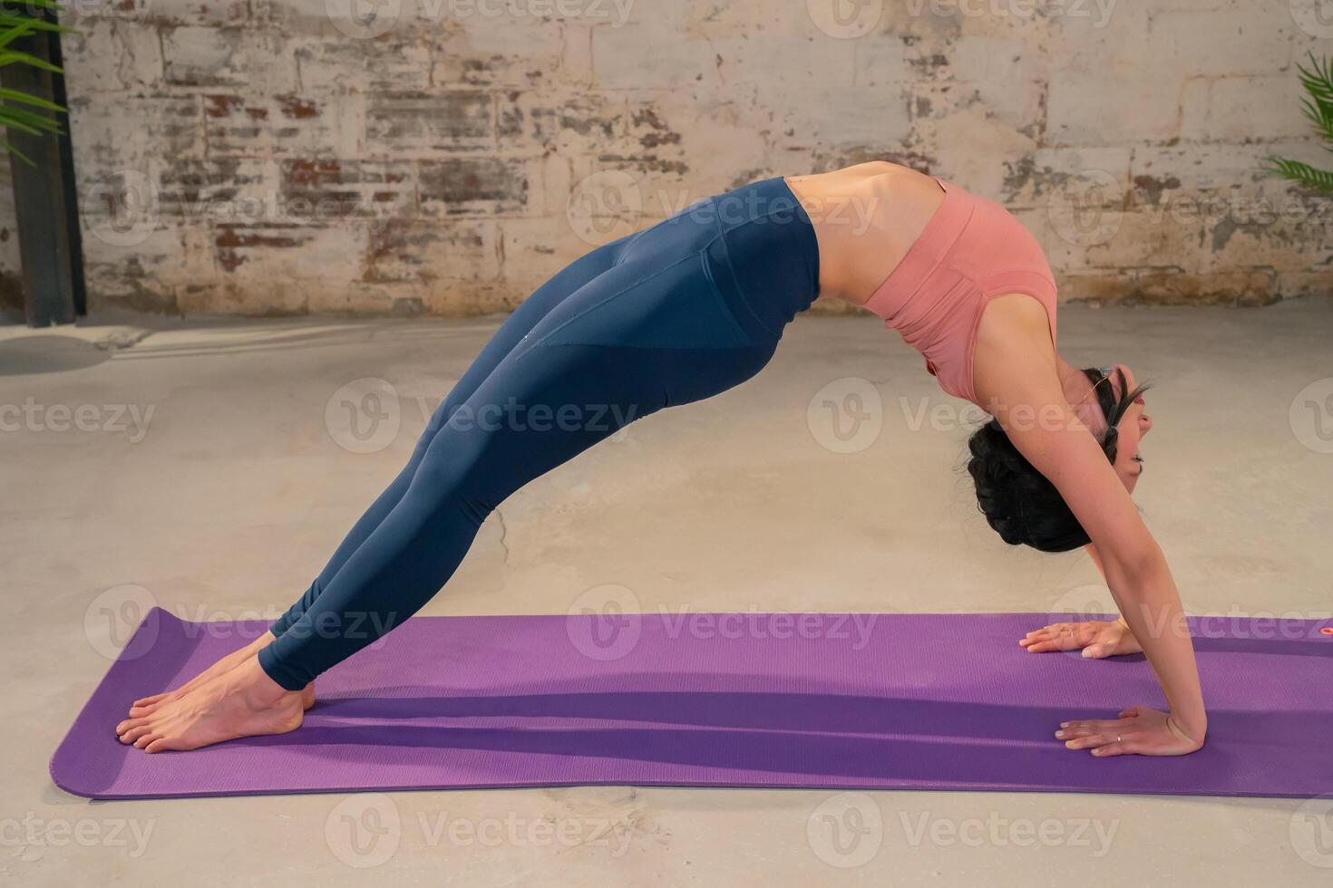 Young woman practicing yoga pose in a industrial gym. photo