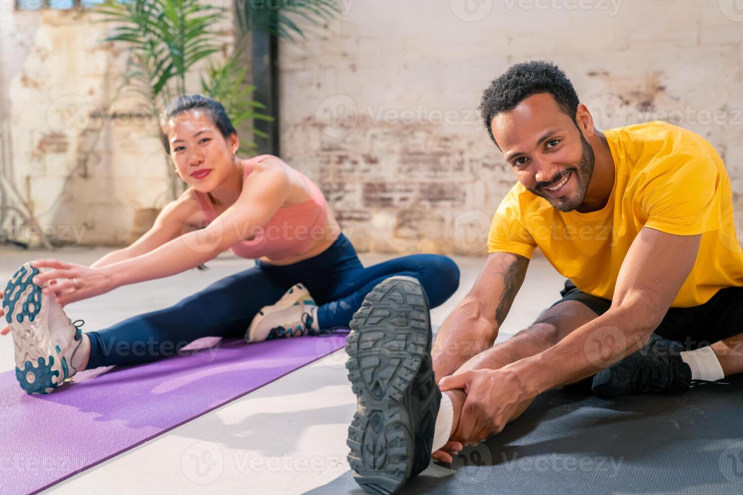 Mixed race sporty man and girl doing exercise together in a industrial gym. photo